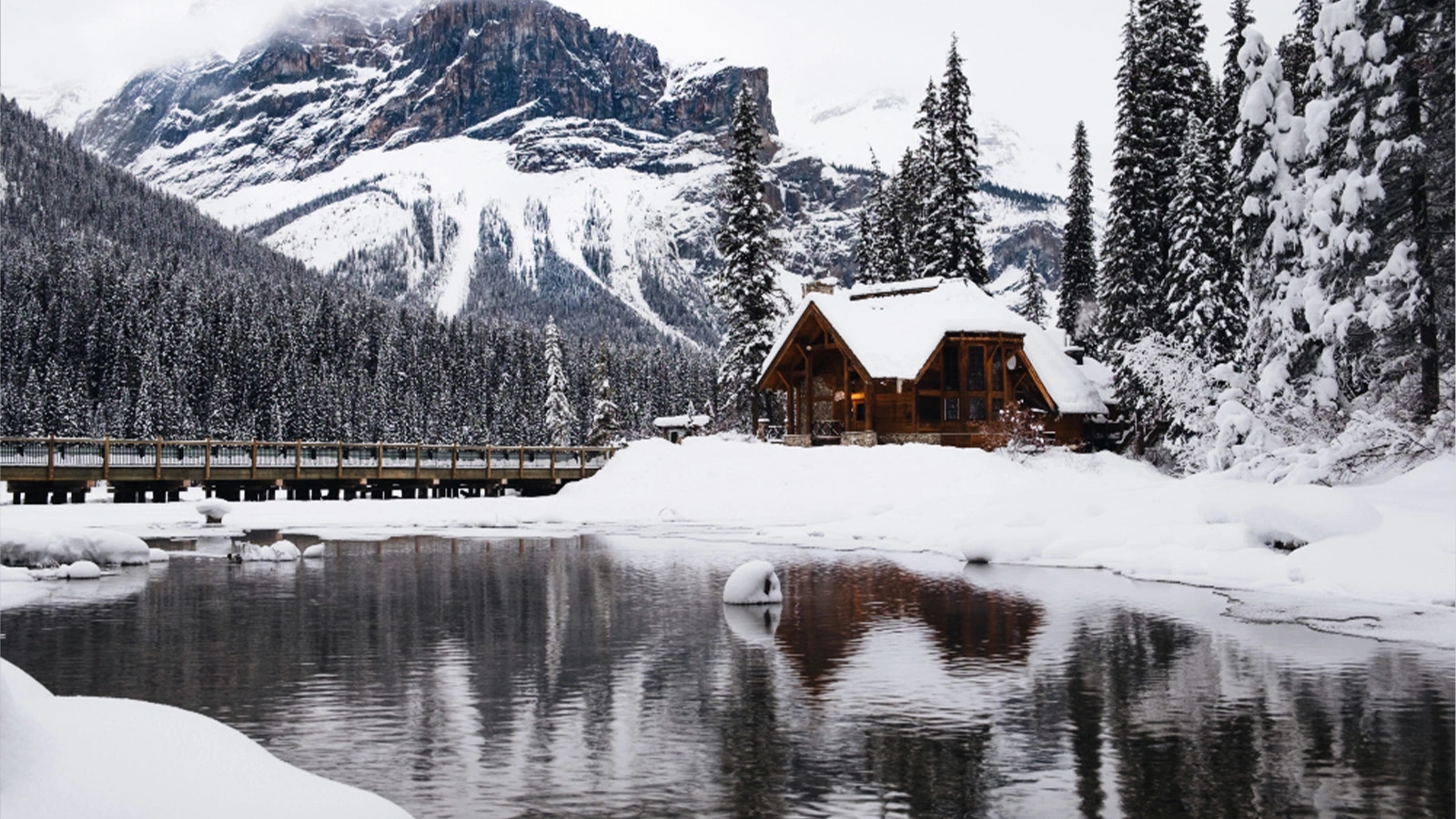 Snow covered seasonal lake house in British Columbia for winter property preparedness
